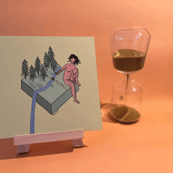 Photographie de l’œuvre en forêt qui représente un personnage assis sur un cube avec une forêt et une rivière qui déborde du cube et tombe hors cadre