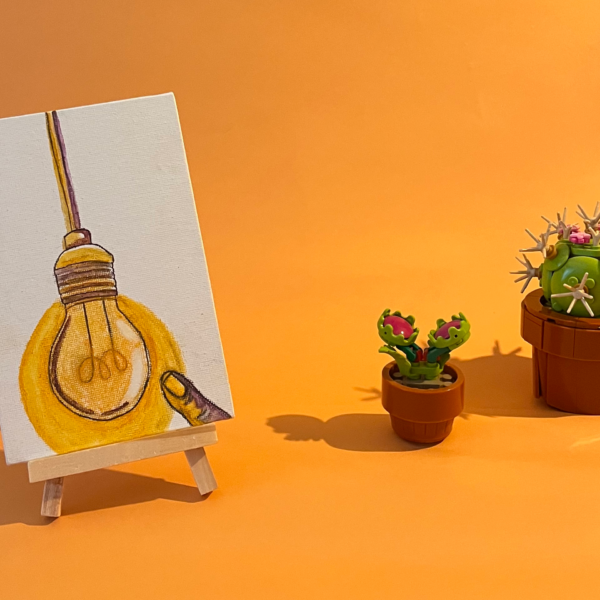 Photographie de l'oeuvre unique originale : une ampoule qui brille avec un doigt qui s'en approche