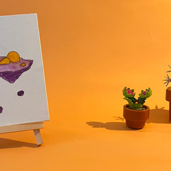 Photographie de l'oeuvre unique originale : une île flottante, littéralement. Un amas de rocher avec deux cailloux jaunes et deux petites fleurs.