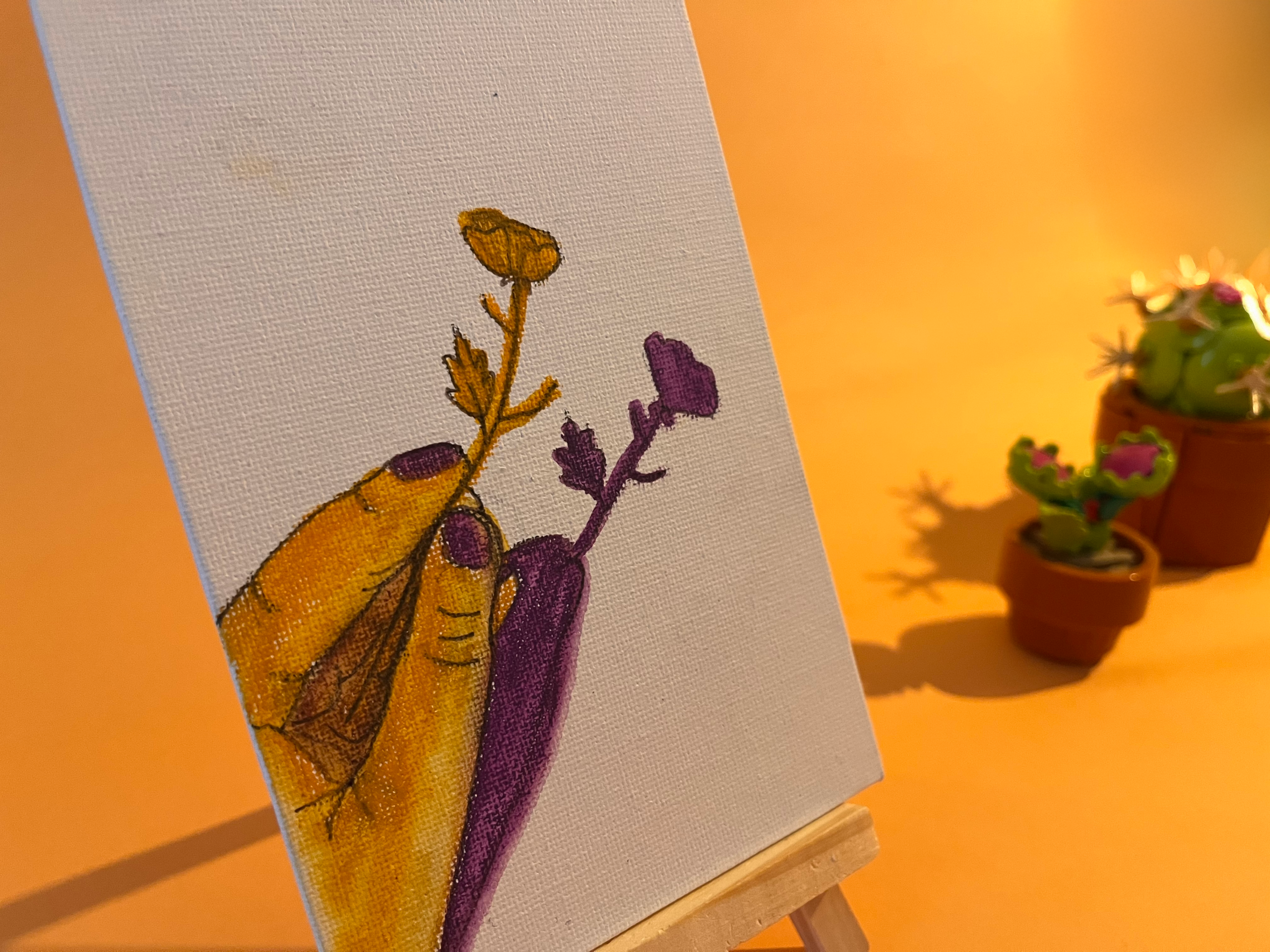 Photographie de l'oeuvre unique originale : une main tenant une fleur, on voit aussi son ombre projetée au sol en violet