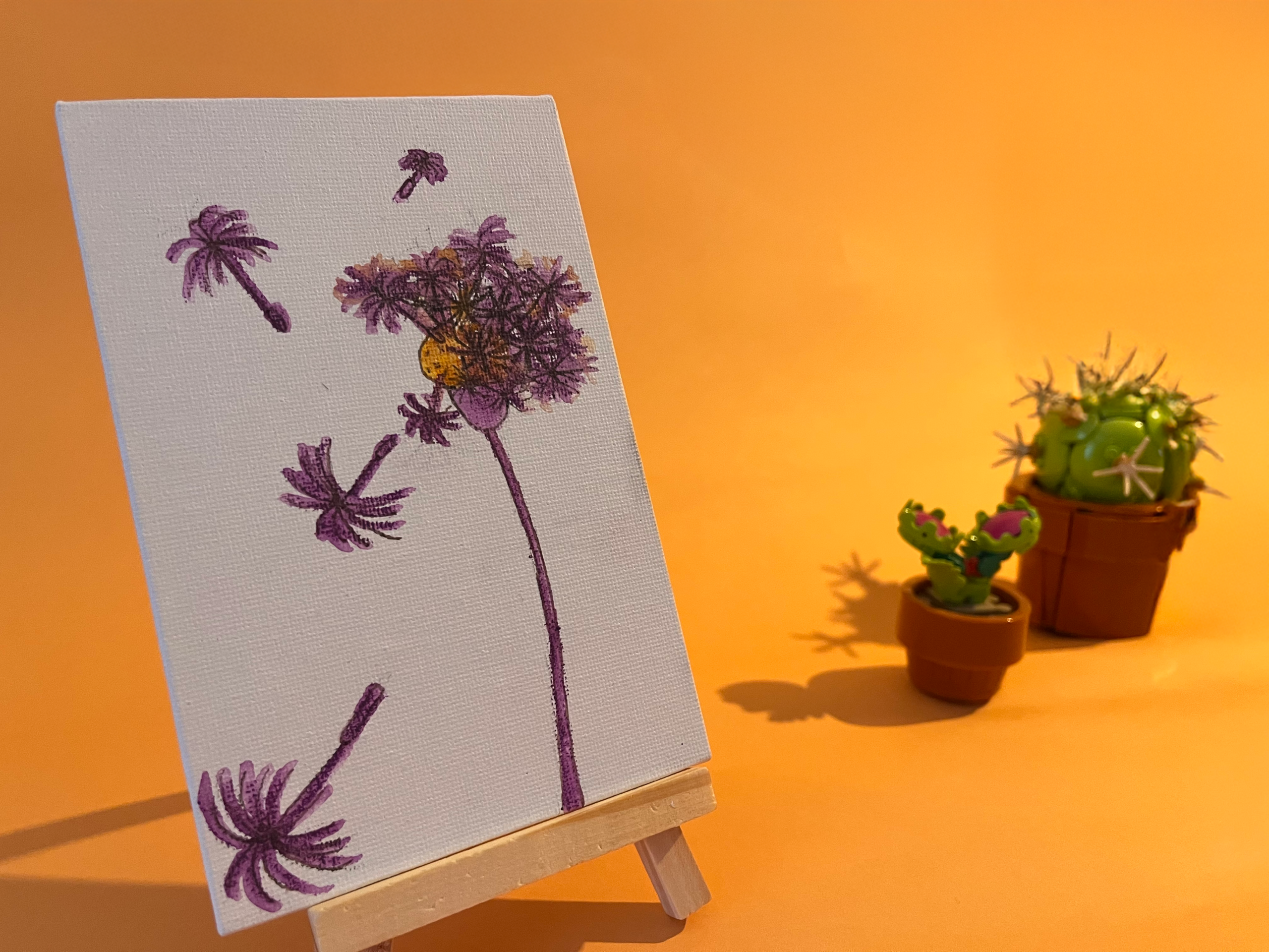 Photographie de l'oeuvre unique originale : un pissenlit sur lequel on a soufflé dont certains pistils s'échappent