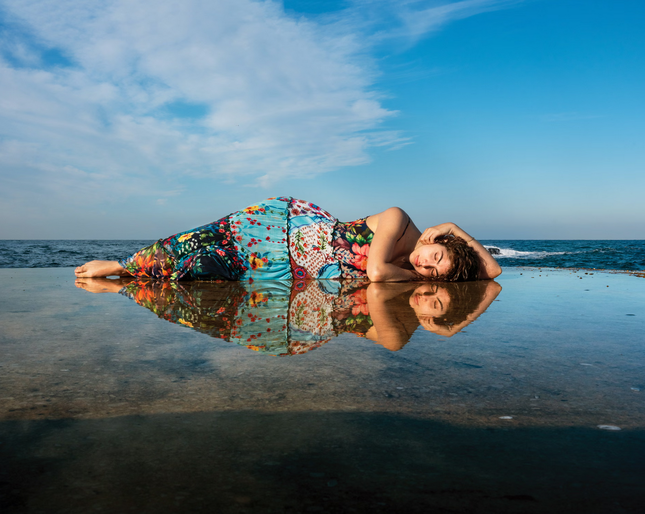 Photographie d'une femme allongée sur le sable mouillé
